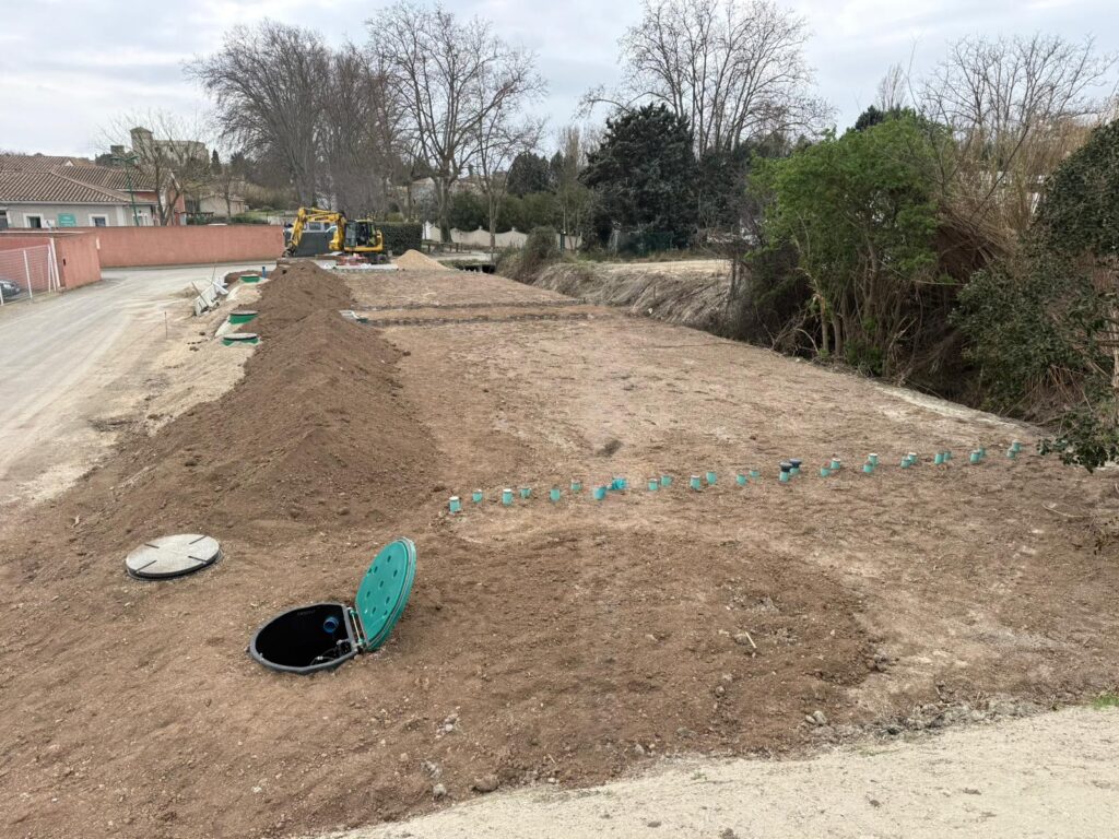 Filière d'assainissement semi-collectif EnviroSeptic drainé recouvert de terre végétale à la fin du chantier