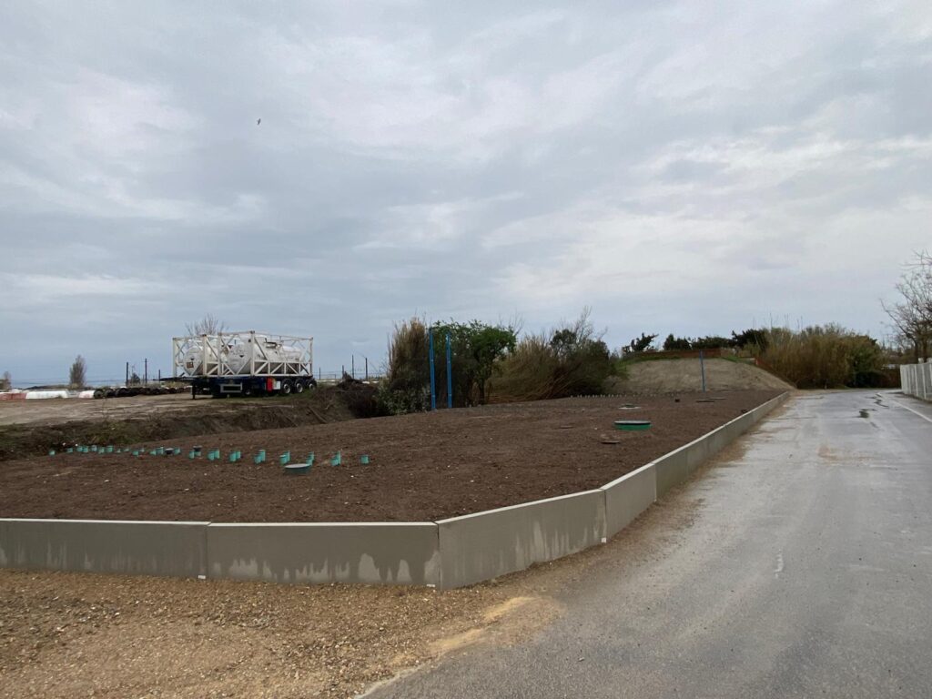 Filière d'assainissement semi-collectif EnviroSeptic drainé, vue générale du remblai en terre végétale à la fin du chantier